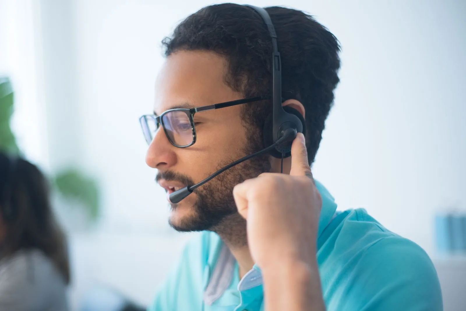 A man wearing eyeglasses and over-ear headphones listening attentively in a clinical or audiology setting